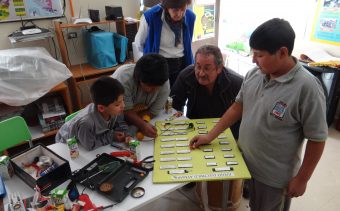 Profesor Fernando Fernández junto alumnos, revisan tablero eléctrico