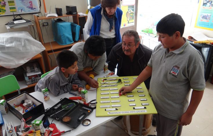 Profesor Fernando Fernández junto alumnos, revisan tablero eléctrico