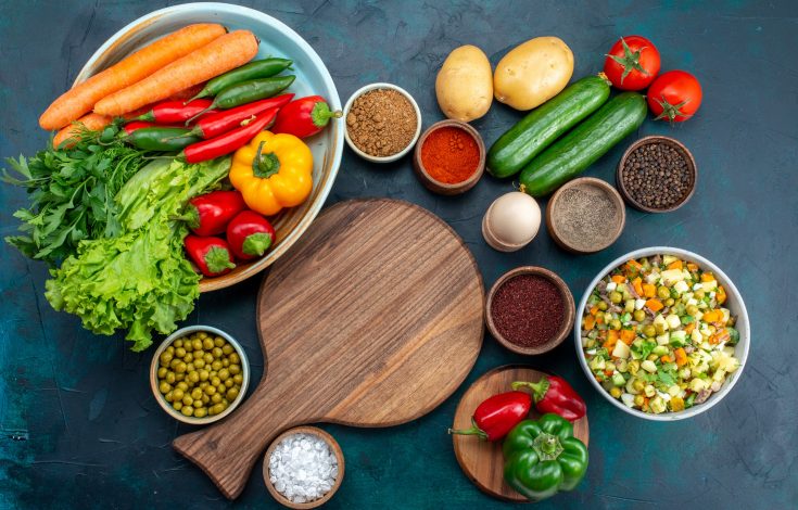 top-view-sliced-vegetable-salad-peppered-with-chicken-slices-inside-plate-with-fresh-vegetables-on-the-blue-desk-snack-lunch-salad-vegetable-food